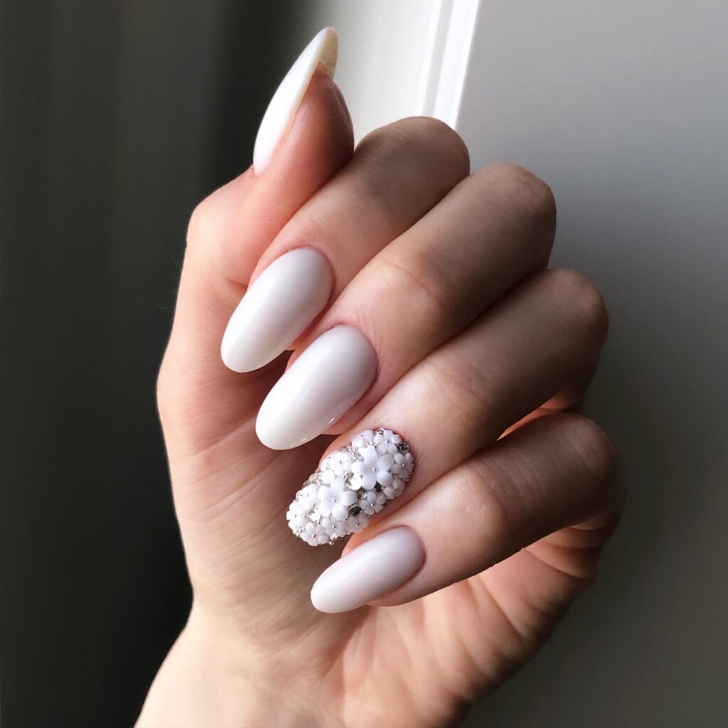 Almond Milky White Nails with 3D Floral Accents – Romantic White Nail Ideas for Special Occasions