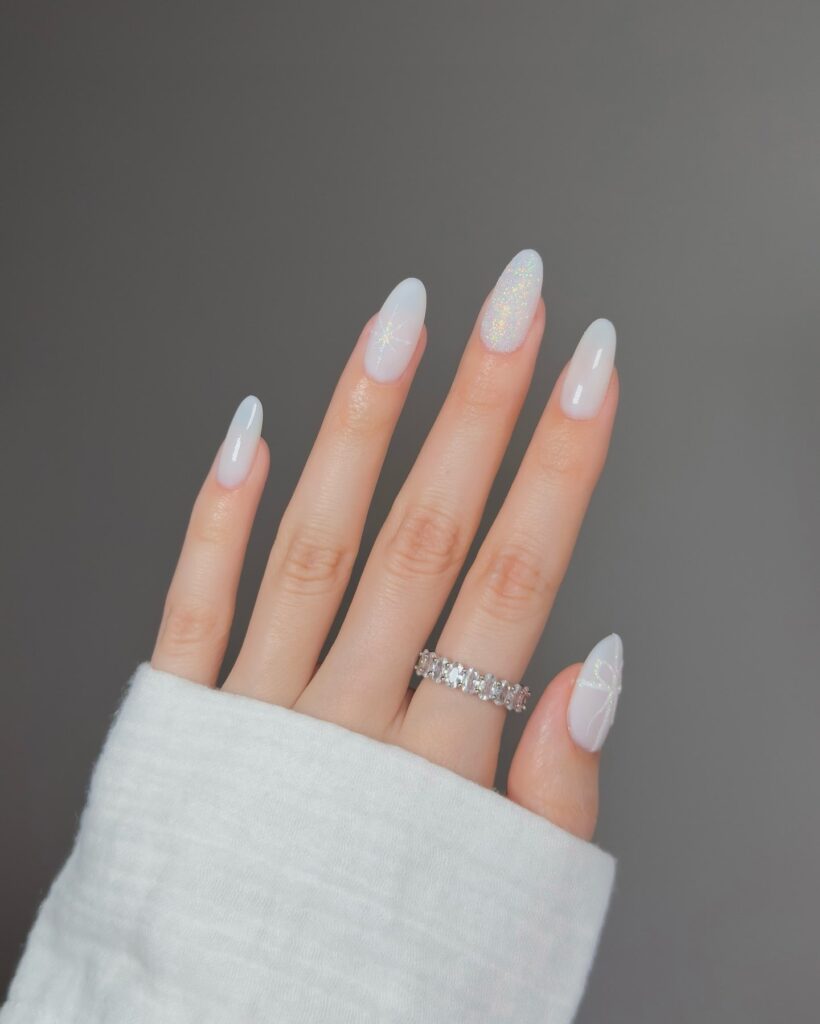 Almond Nails with Milky Base, White Stars, and Holographic Shimmer for a Celestial Vibe