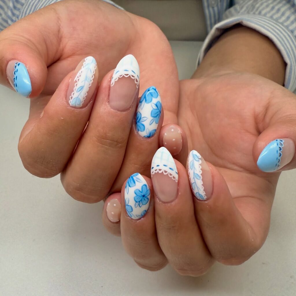 Almond nude nails with blue floral tips and lace designs for a romantic vintage spring nail idea
