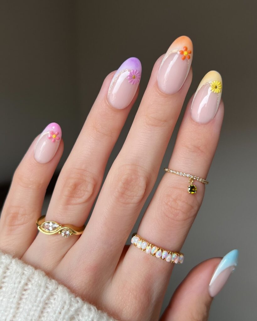 Almond nude nails with pastel gradient tips glitter lines and 3D floral accents for an elegant spring nail look