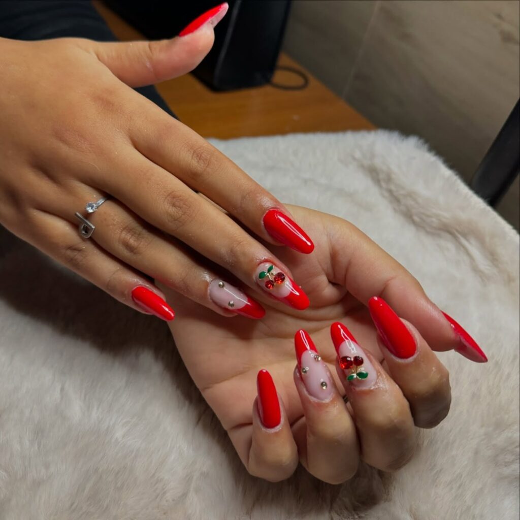 Almond red nails with cherry art and nude accent details for a playful summer look