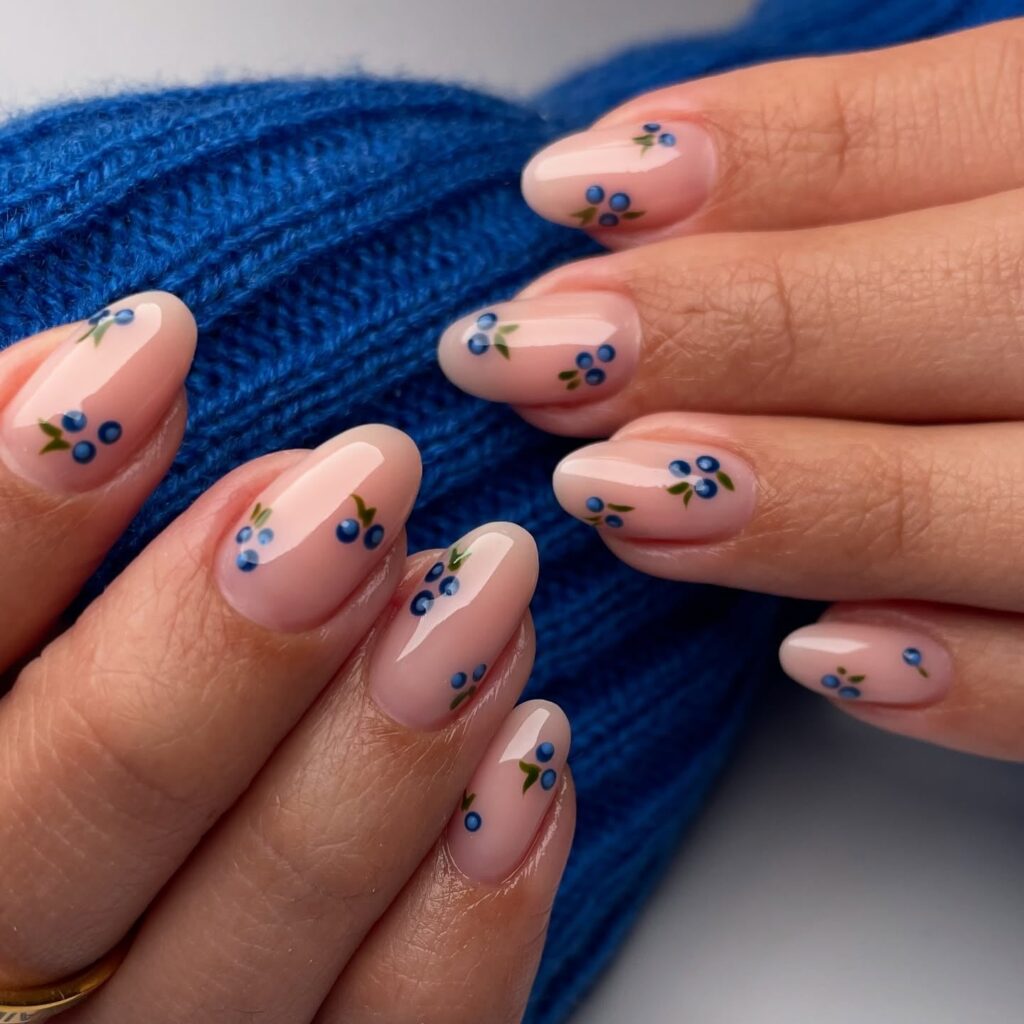 Almond sheer pink nails with tiny blue flowers and botanical accents for a subtle spring floral nail idea