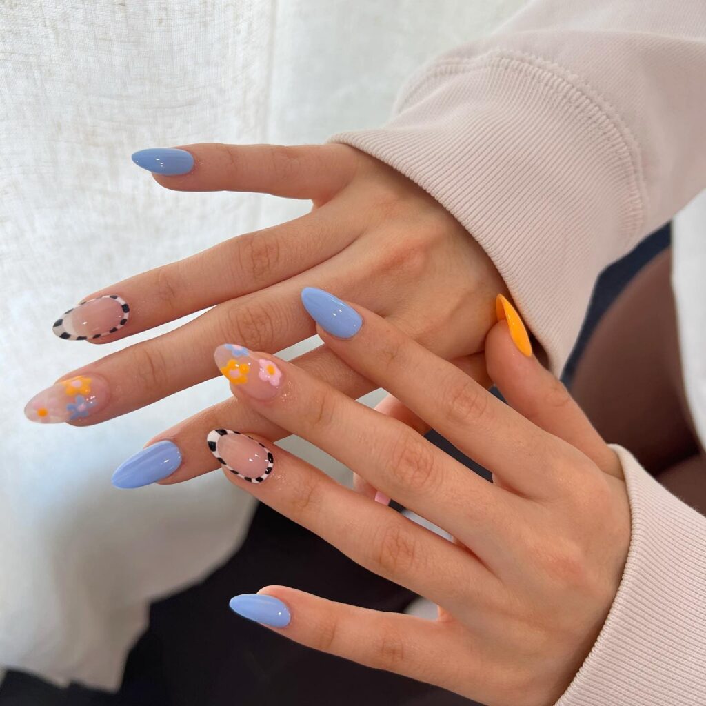 Almond sky blue nails with 3d floral accents and checkerboard outline art nail ideas