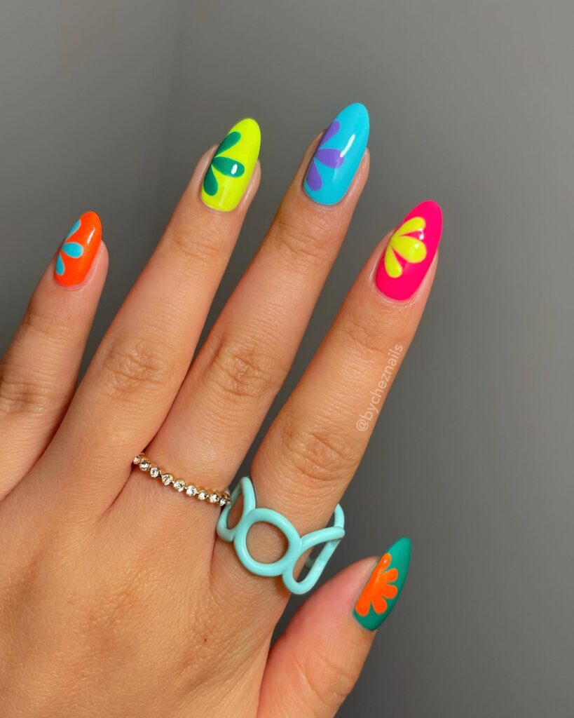 Bold Rainbow Almond Nails with Neon Abstract Petal Designs for a Playful Summer Vibe