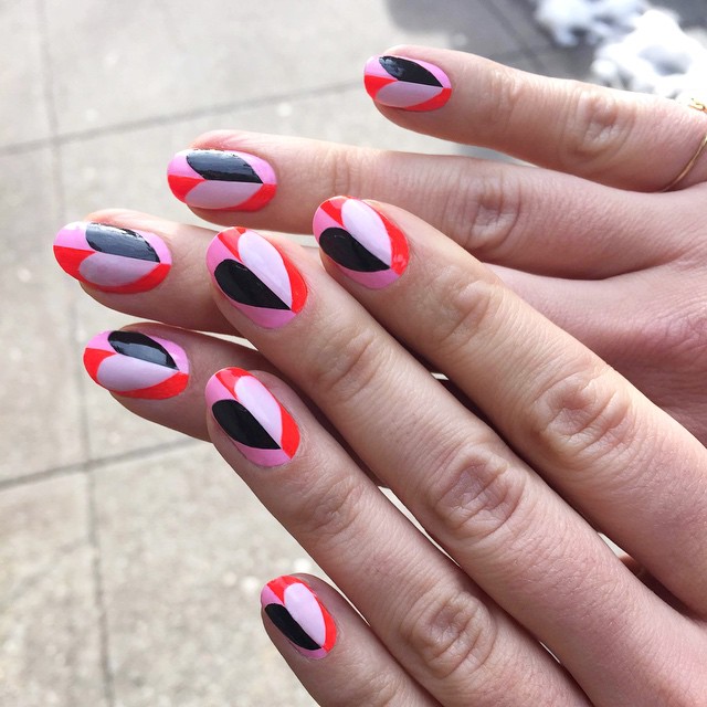 Bold Almond Nail Art with Soft Pink Base and Vibrant Geometric Petal Shapes