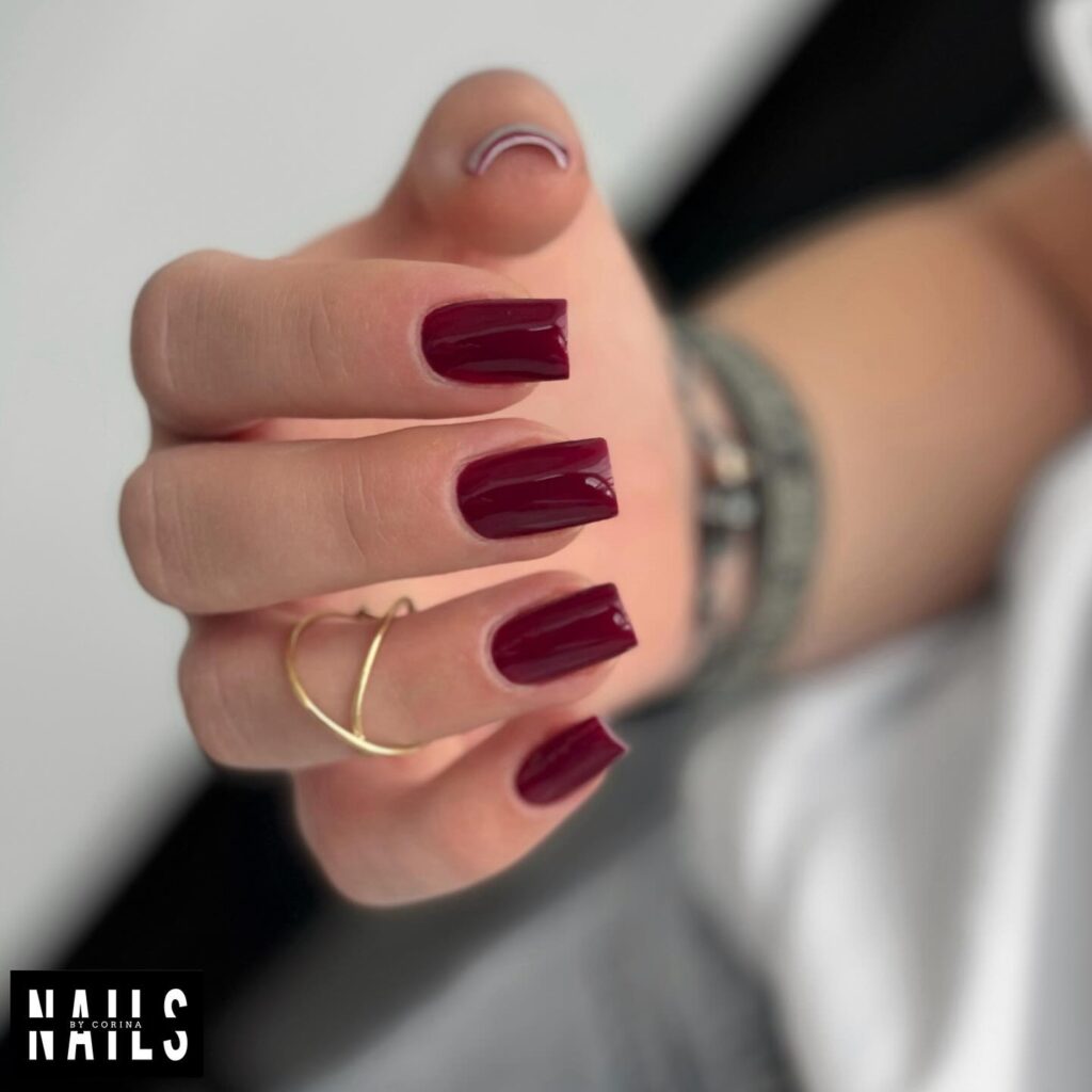 Bold burgundy square nails with minimalist white detail for a modern fall look