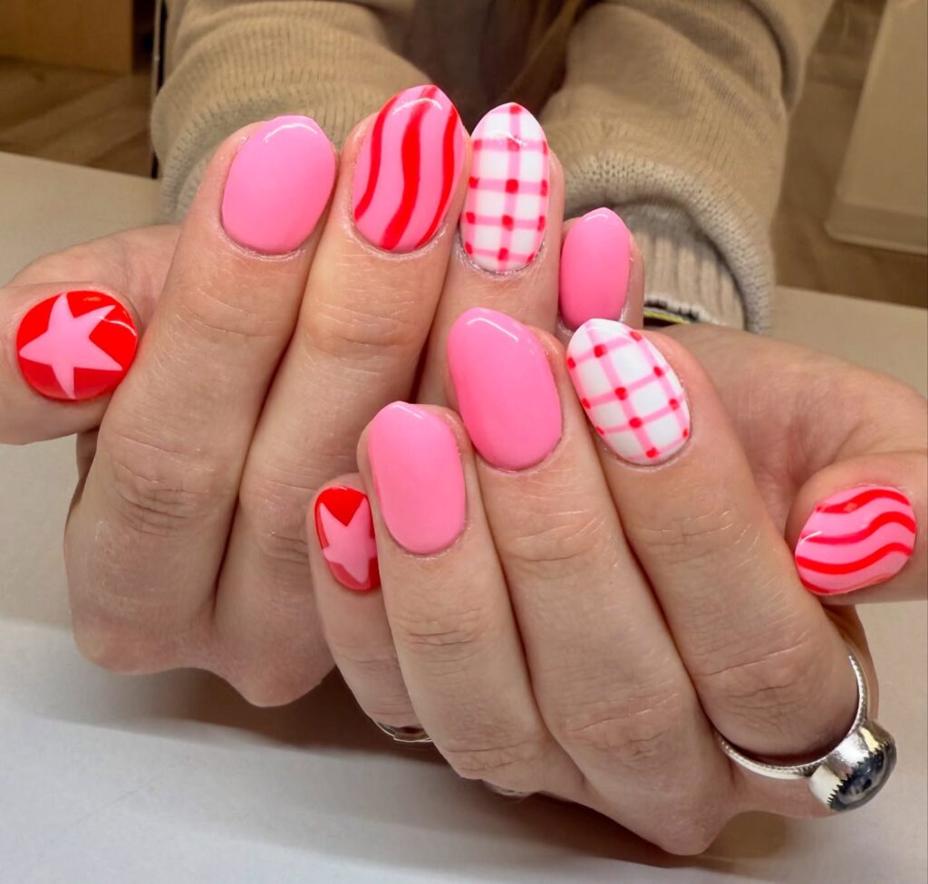 Bold Pink and Red Oval Nails with Stars and Checkers for Fun May Nail Ideas