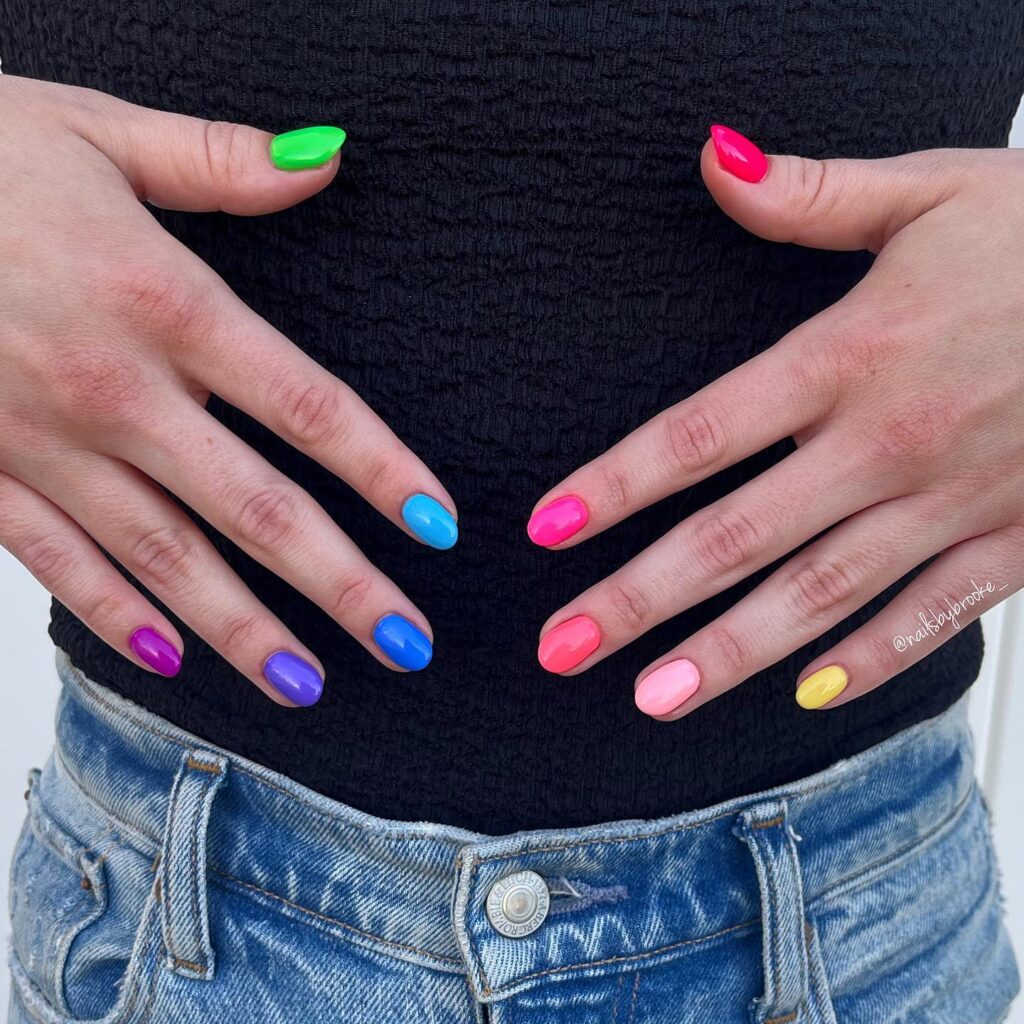 Bright rainbow short rounded nails in neon shades perfect for playful summer vibes