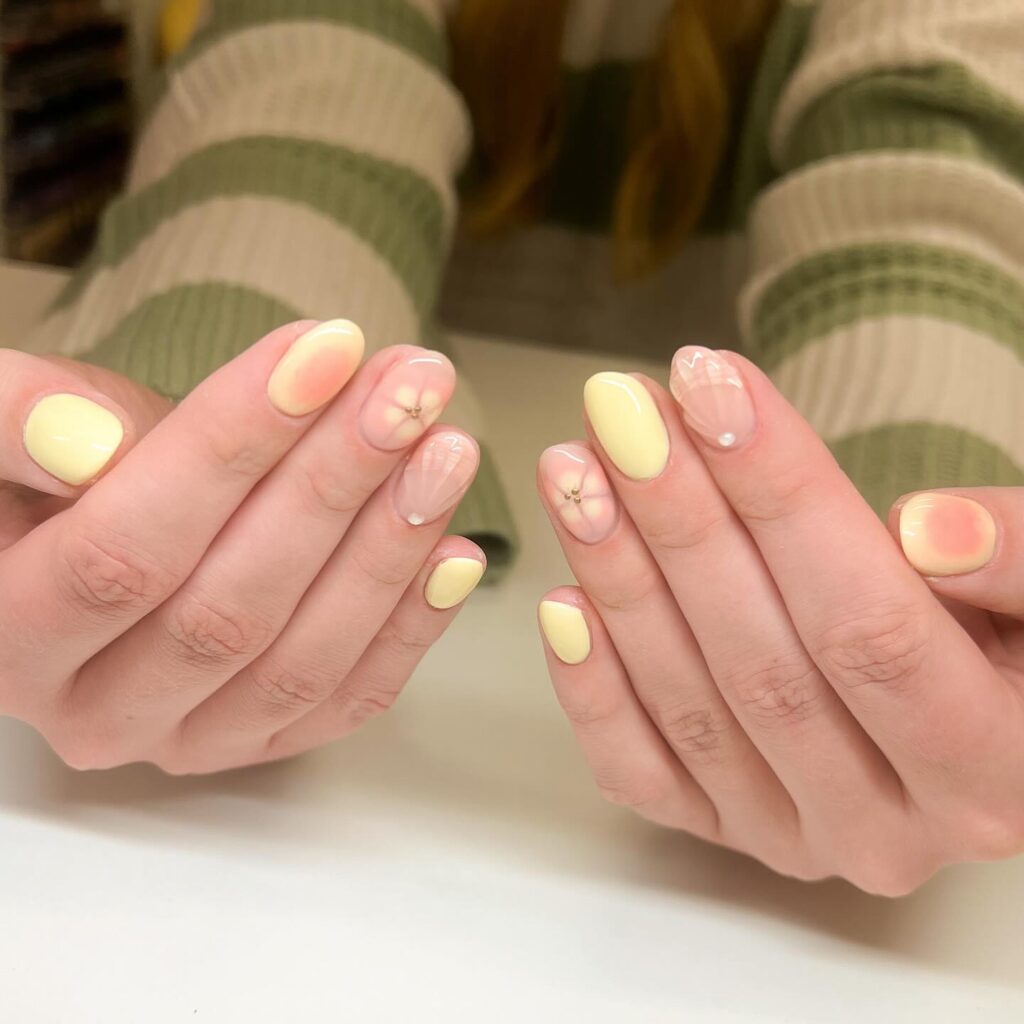 Cheerful Almond Nails with Yellow Polish and Delicate Floral Studs
