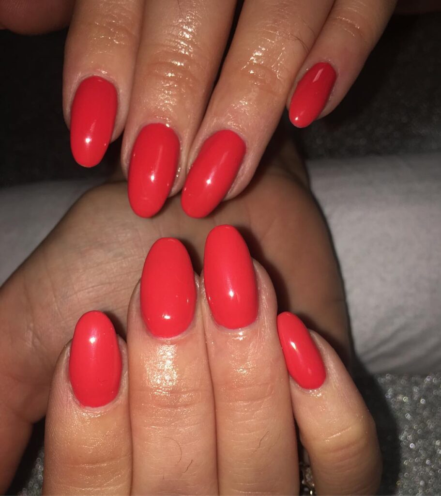 Chic coral red oval nails that bring a touch of elegance to your everyday style