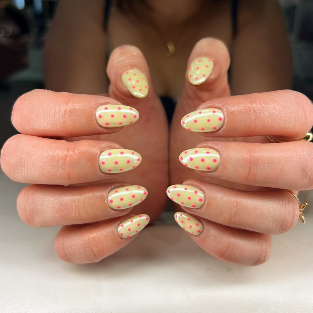 Creamy Yellow Almond Nails with Hot Pink Polka Dots for a Retro Pop