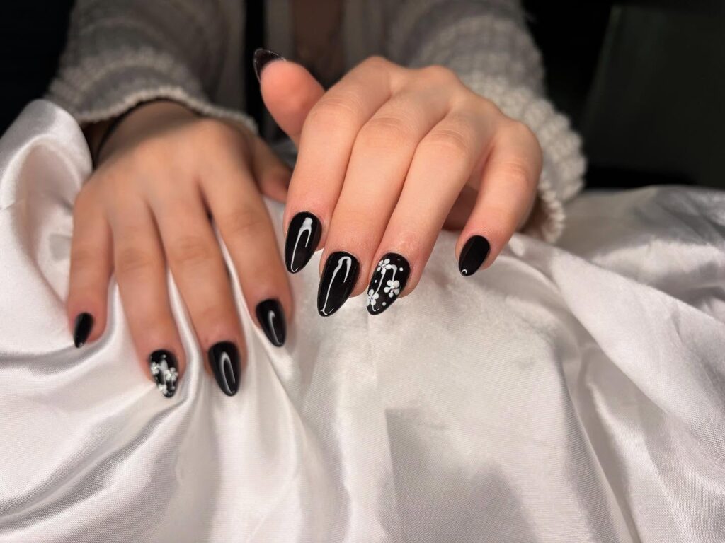 Elegant Almond Black Nails with White Floral and Petal Designs