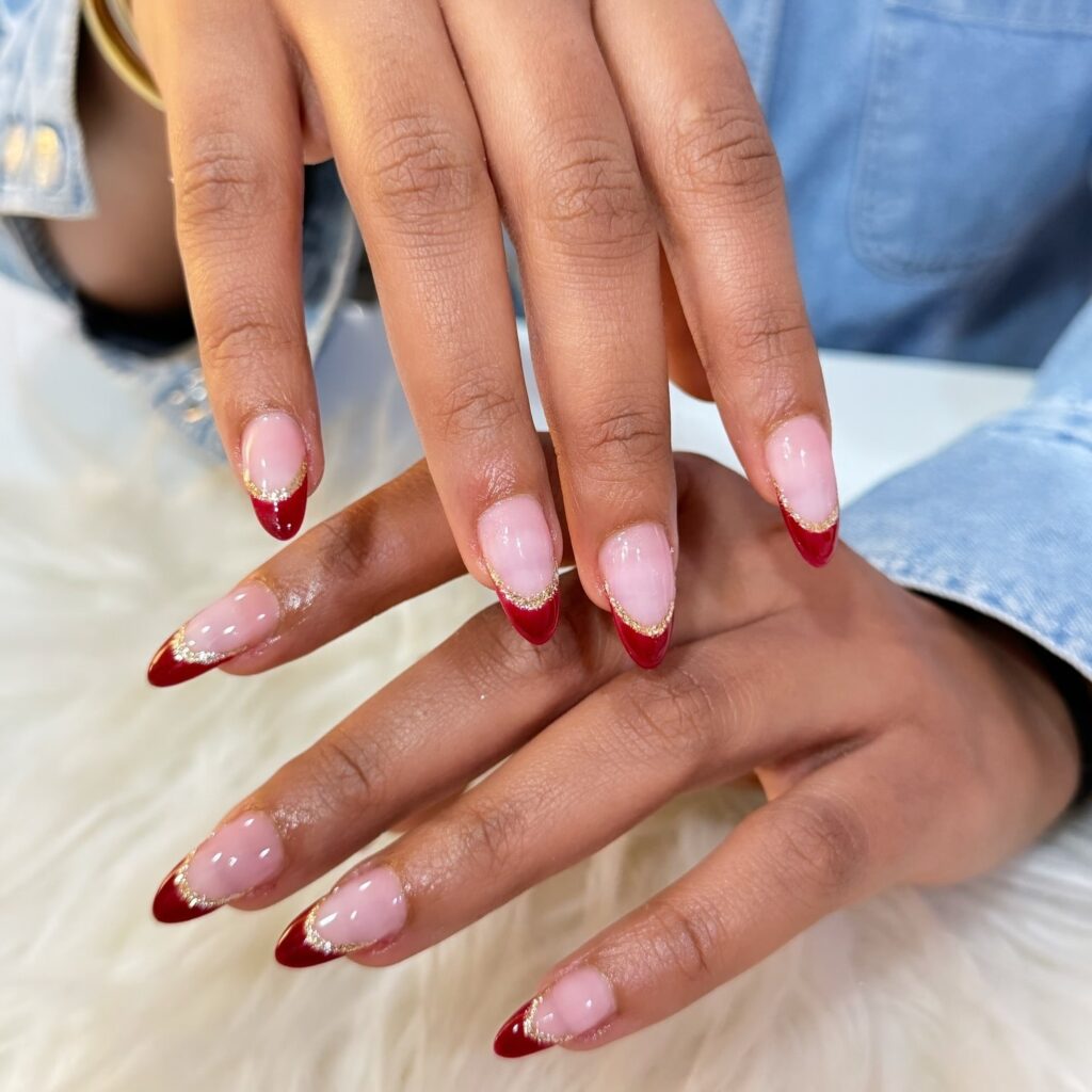 French red tip almond nails with gold accents for a luxurious holiday nail idea