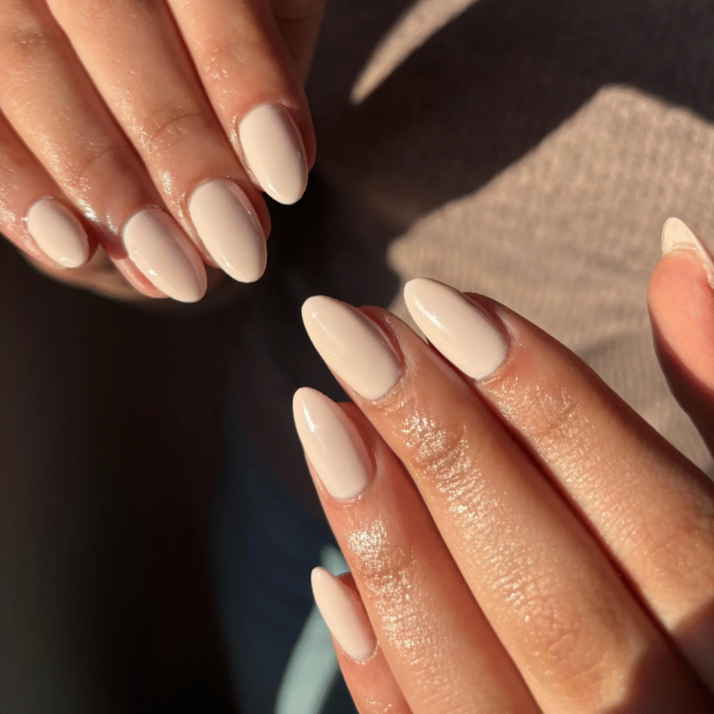 Glossy nude almond nails for subtle and elegant white nail ideas