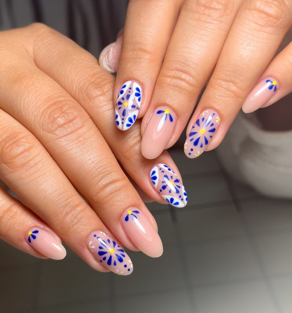 Glossy Nude-Pink Almond Nails with Blue and Yellow Porcelain-Style Daisies