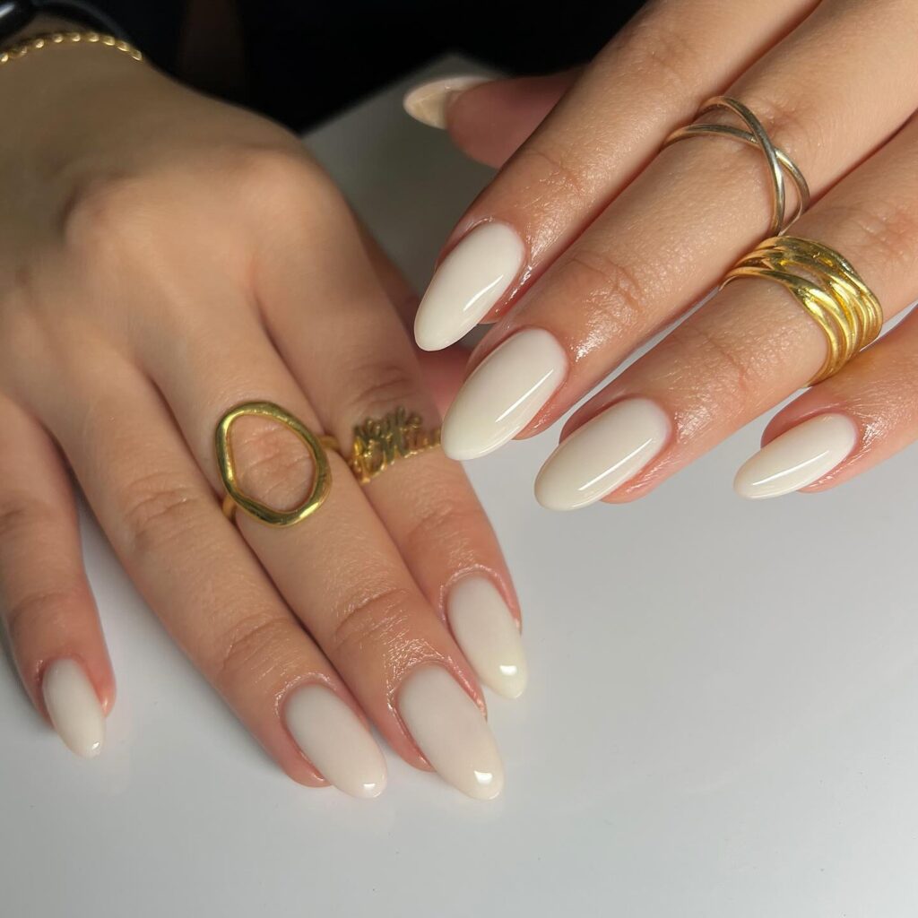 Ivory nude almond nails with a glossy finish for timeless white nail inspiration