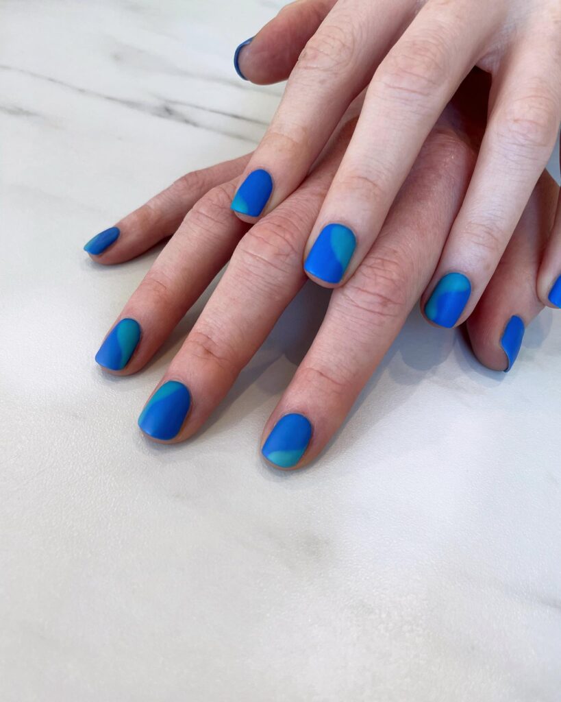 Matte blue abstract round nails ocean inspired nail ideas with contemporary curves