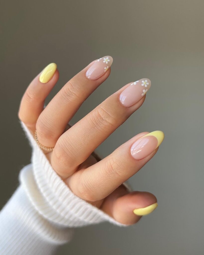 Nude almond nails with daisies and yellow french tips – light and fresh yellow nail ideas for spring