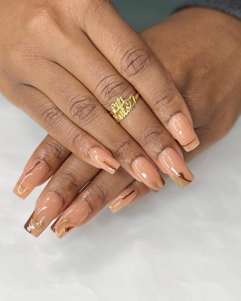 Nude coffin nails with caramel swirl tips modern neutral nail ideas with artistic detail