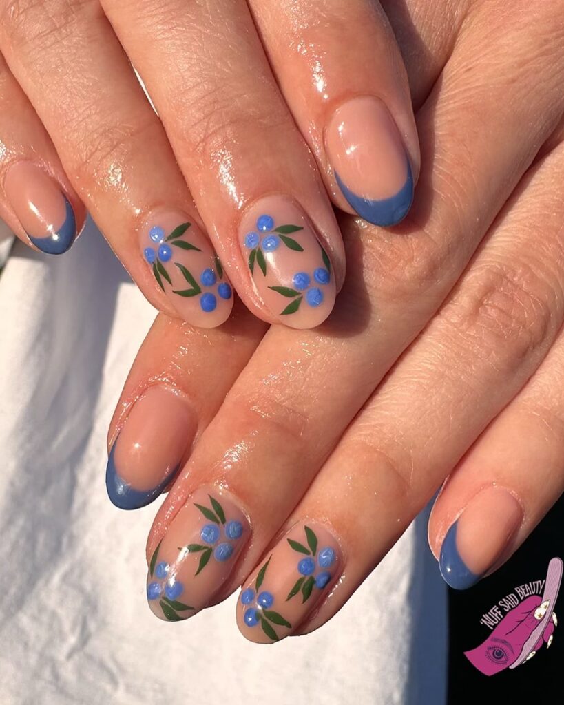 Nude nails with blue French tips and floral garden accents for fresh May looks