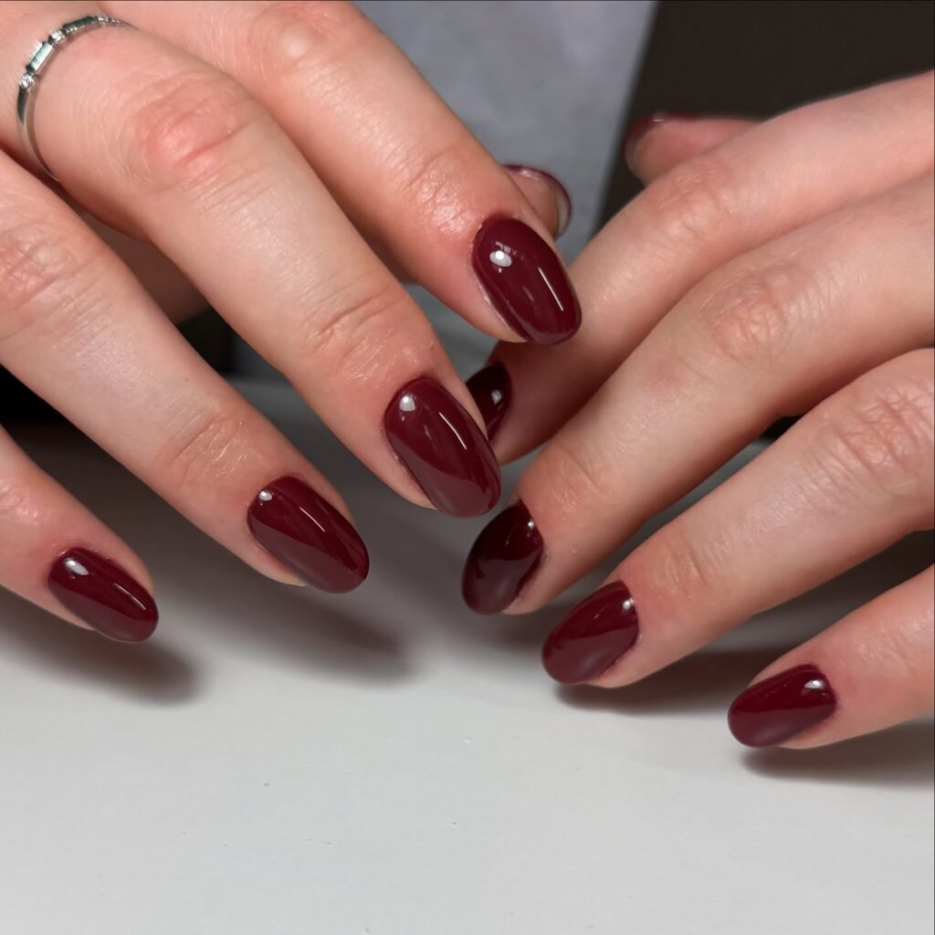 Oval burgundy nails with glossy finish for elegant May nail ideas