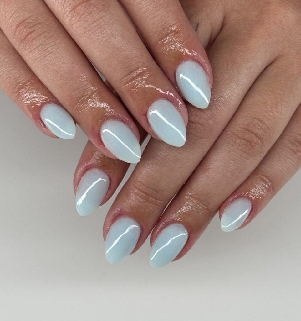 Pale blue gradient almond nails with a glossy ombré effect for a calm and minimalist nail idea