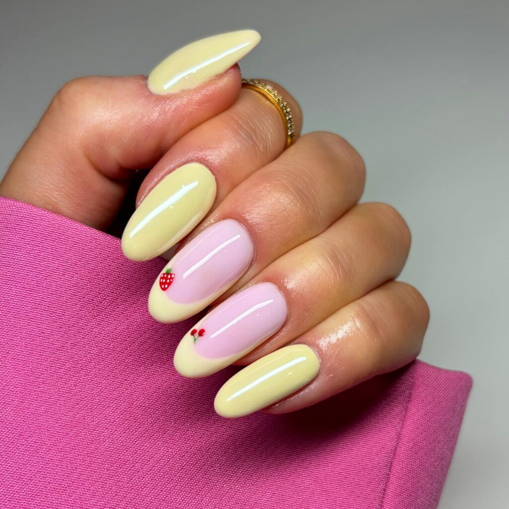 Pale yellow almond nails with fruit french tips – cute and whimsical yellow nail ideas for warm weather