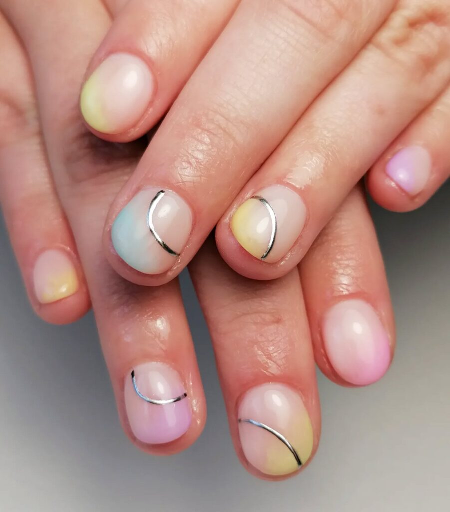 Pastel ombre rounded nails with silver lines creating soft spring nail ideas