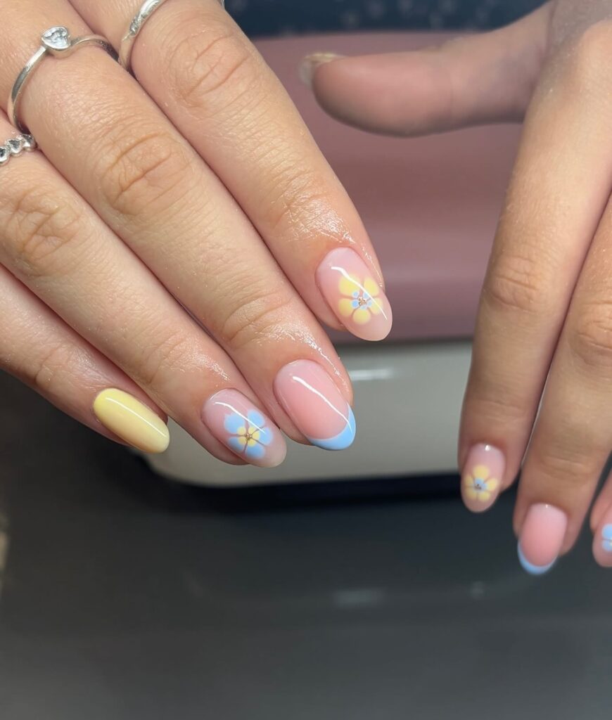 Pastel Yellow and Blue French Tips with Daisy Nail Art on Almond Nails