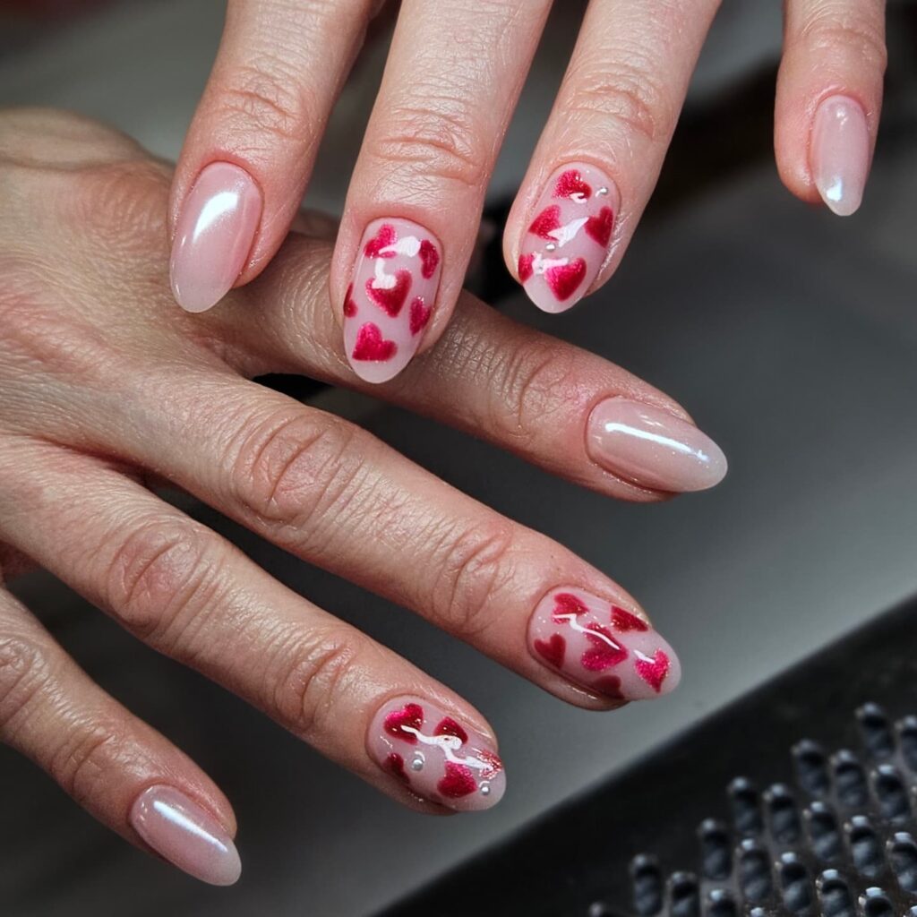 Romantic Almond Nails with Translucent Pink Base and Glossy Red Heart Accents