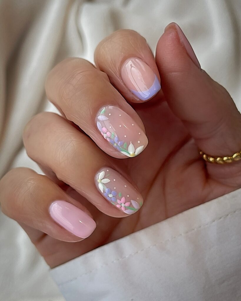 Rounded nude nails with hand painted pastel floral accents and a lavender gradient for a romantic spring look