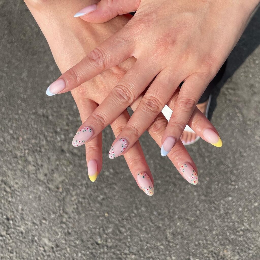 Sheer nude almond nails with multicolored floral dots and pastel French tips for feminine spring style