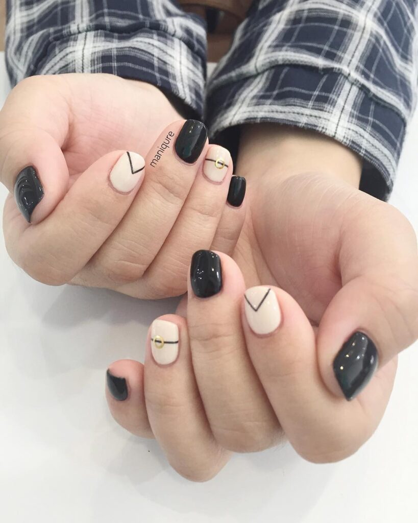 Short Rounded Black and Nude Nails with Geometric Lines and Gold Studs for Modern Minimalism