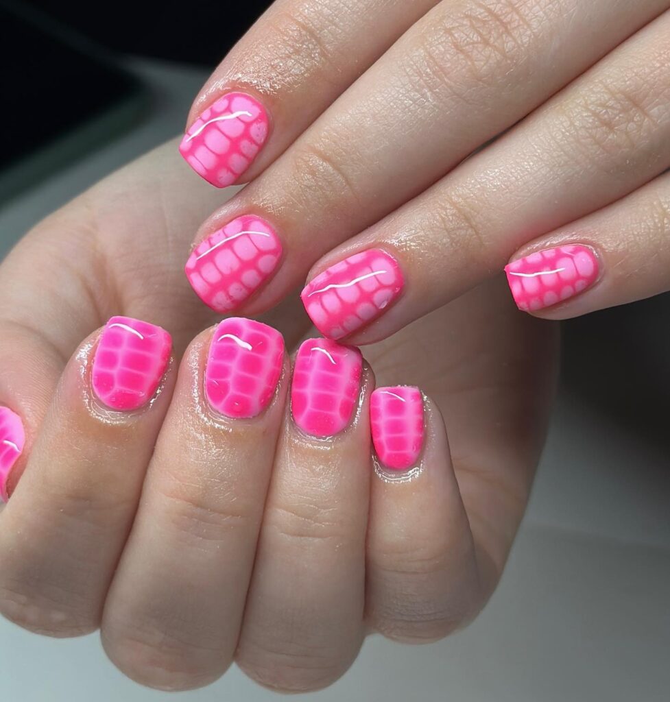 Short square hot pink nails featuring playful grid pattern for bold spring style