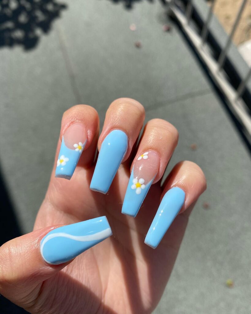 Sky blue coffin nails with daisy accents – spring graduation nail ideas with a floral twist