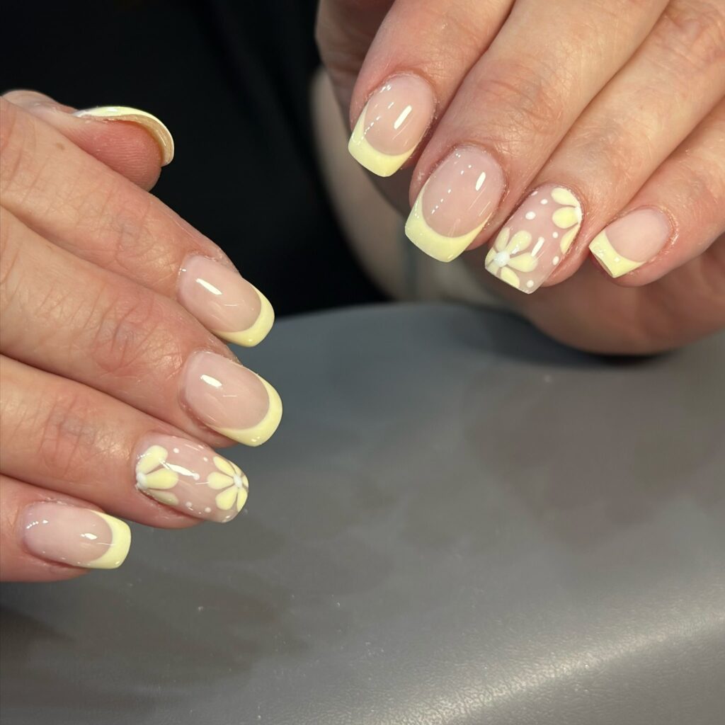 Soft Yellow French Tips on Short Square Nails with Dainty Daisies