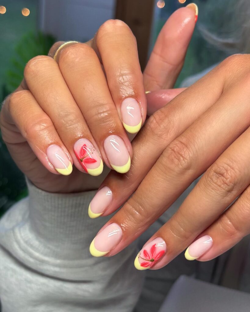 Soft Yellow French Tips with Red Floral Accents on Almond Nails for Spring Sunshine