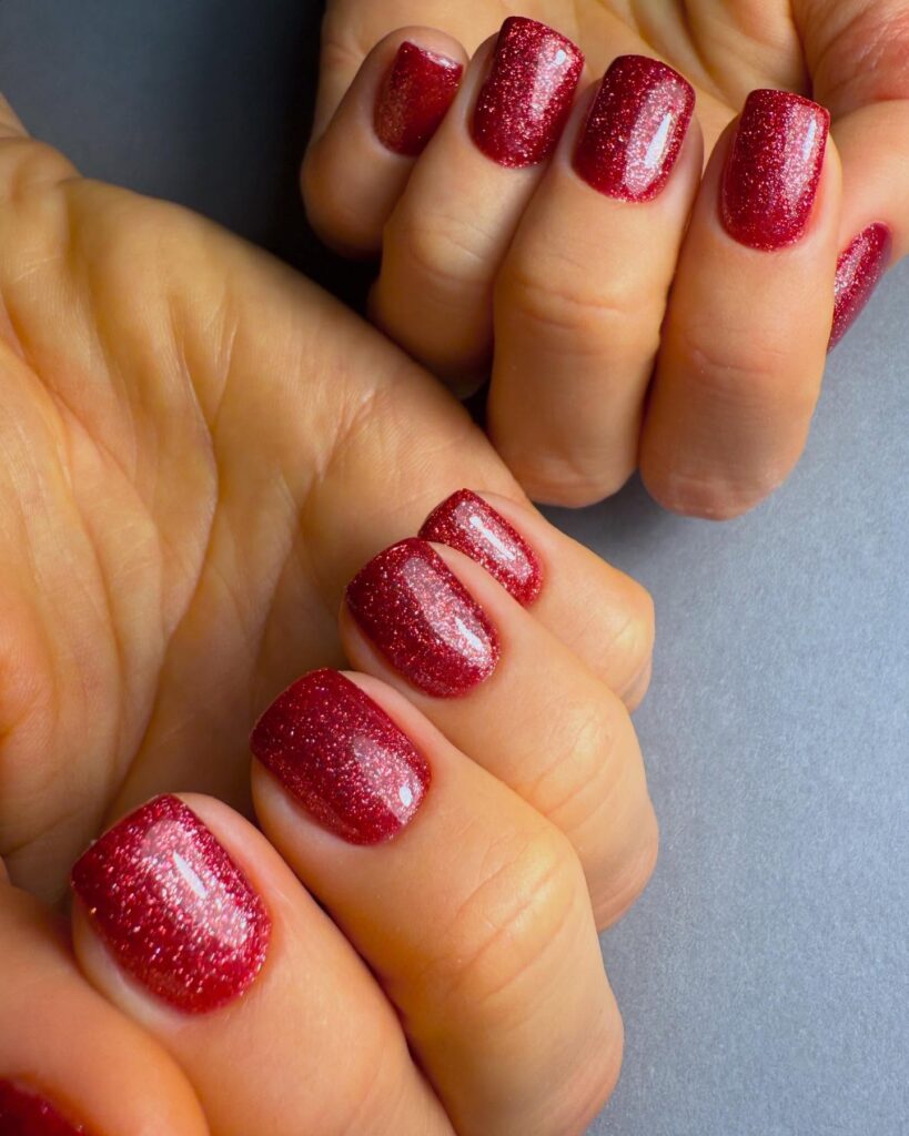 Sparkling red short nails with glitter for a festive and glamorous holiday vibe