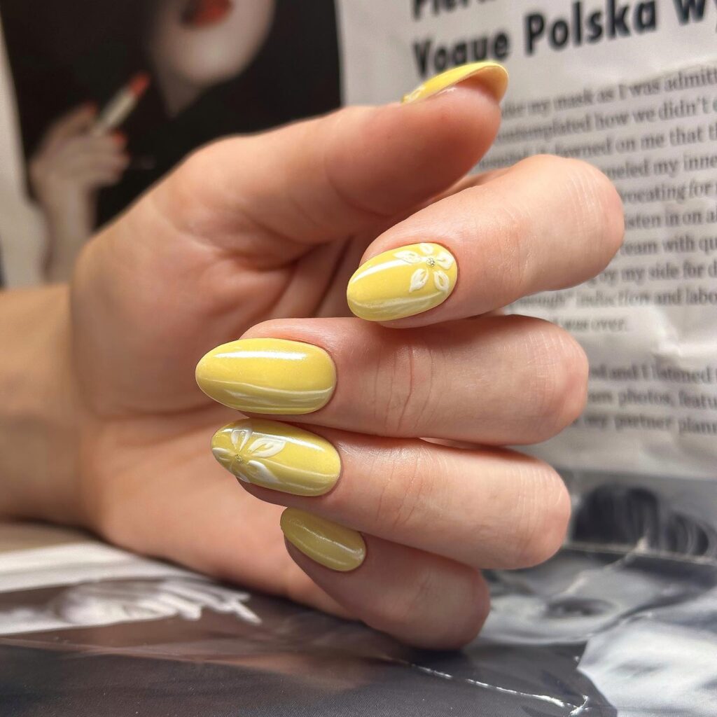 Almond Yellow Nails With White Embossed Floral Designs for Elegant Nail Ideas