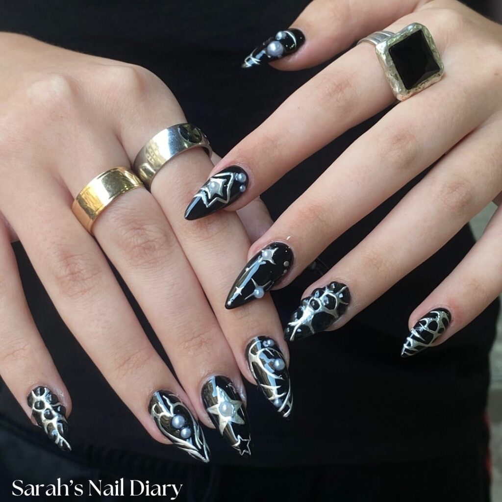 Black almond celestial nails with stars and pearls for a glam graduation vibe