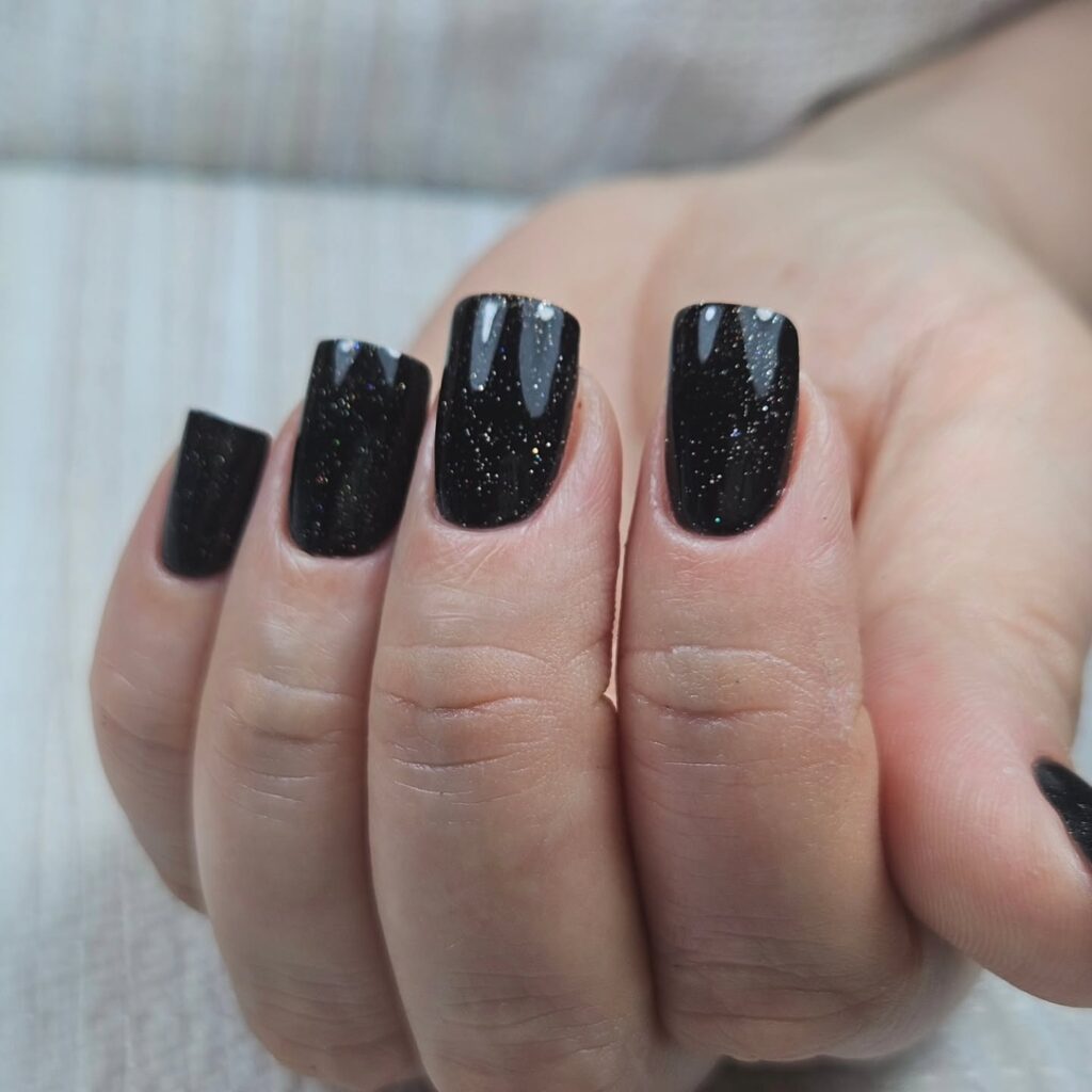 Black glitter square nails with starry night effect for a dreamy glam manicure