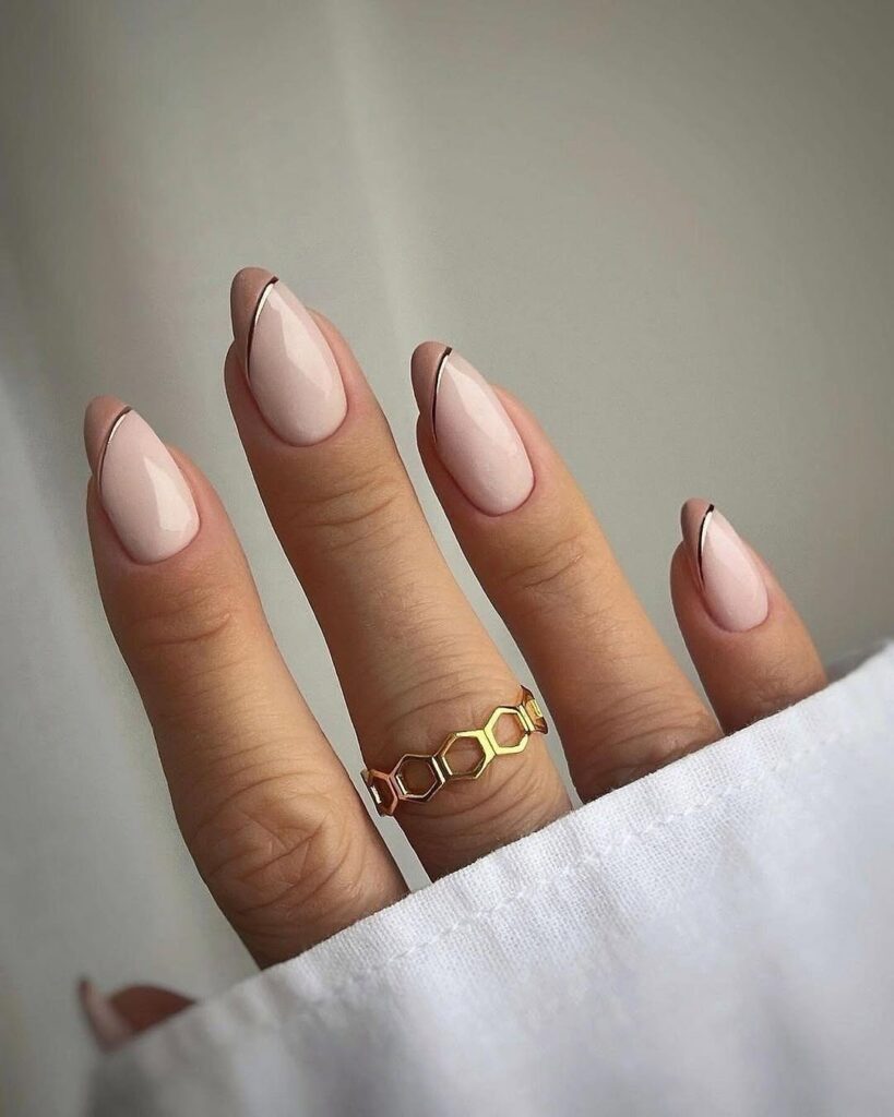 Blush pink almond nails with gold diagonal tips elegant and classy nail design