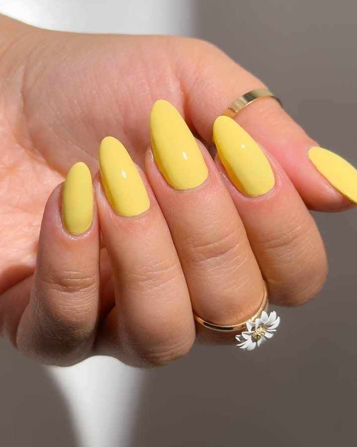 Bright Lemon Yellow Almond Nails With Gold Ring Styling for Floral Summer Vibes