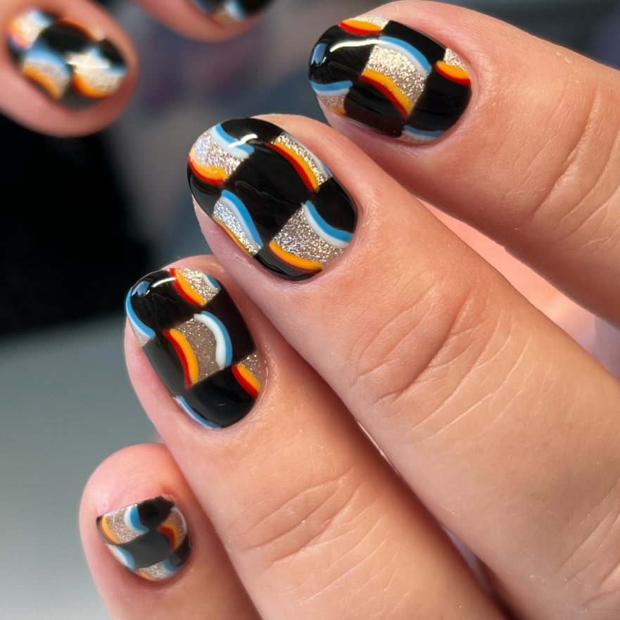 Colorful short rounded nails with wavy checkerboard pattern and glitter details for bold retro nail ideas