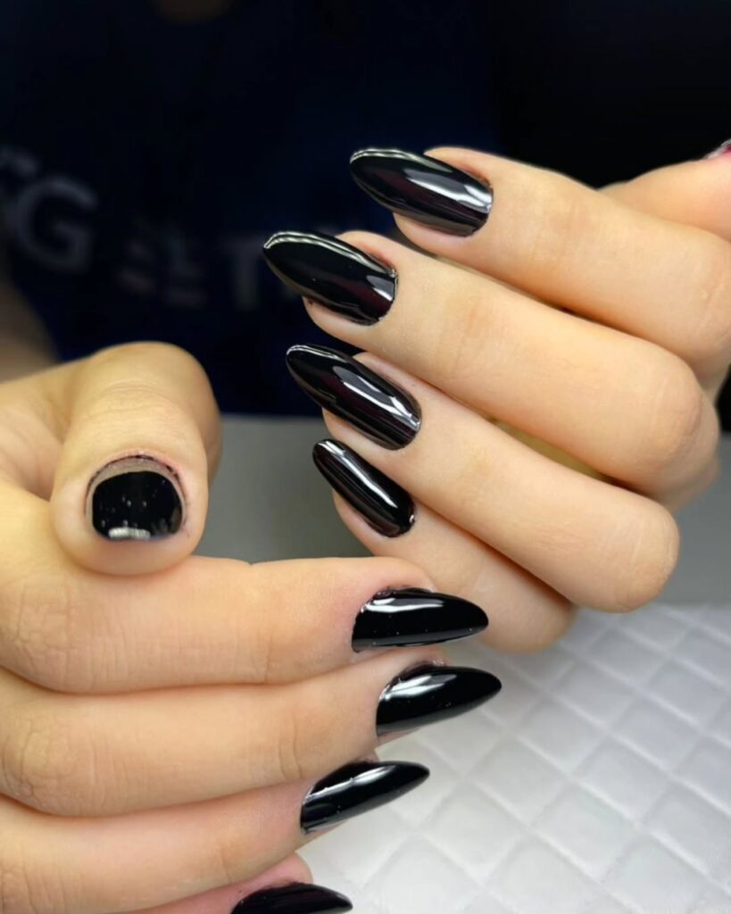 Deep glossy black almond nails with mirror shine for a clean high fashion manicure and nail inspiration