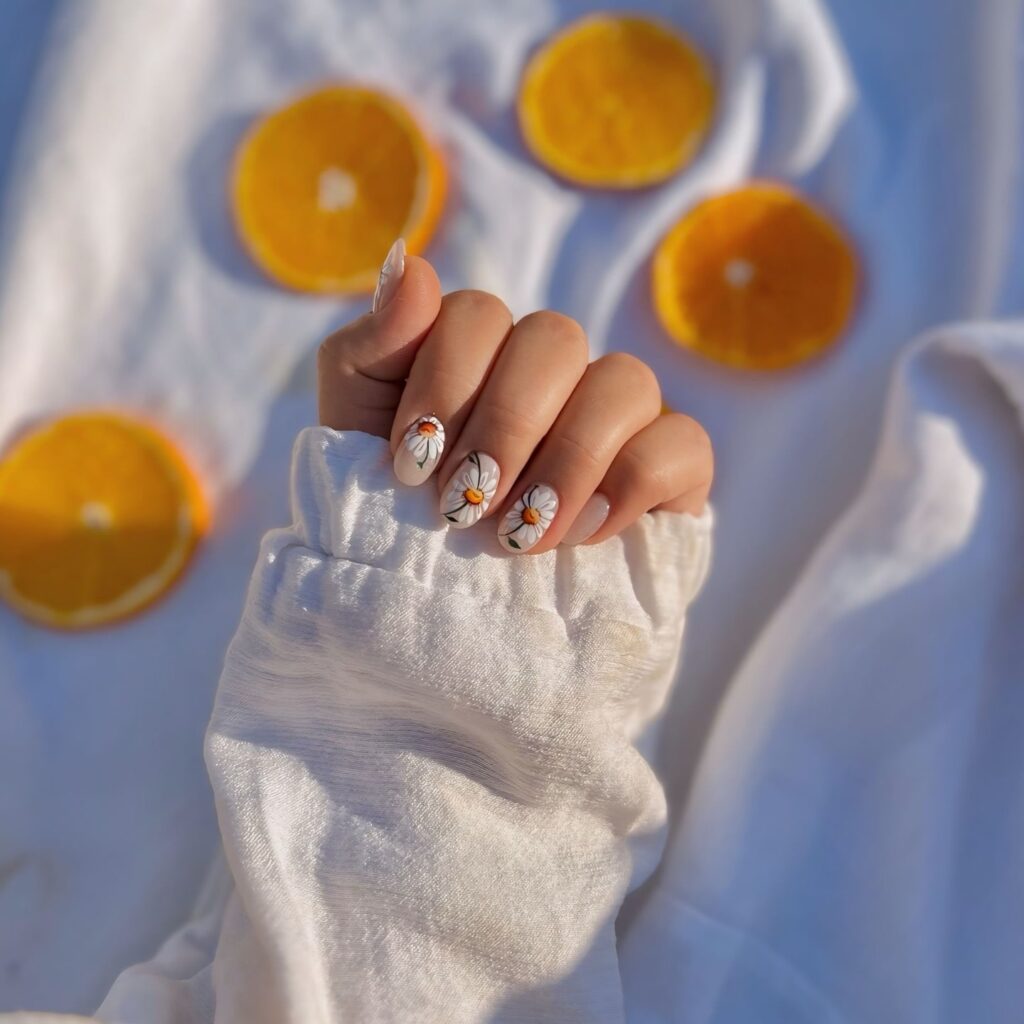 Floral Almond Nails with White Daisies and Orange Accents for Spring