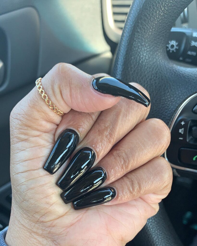Long stiletto coffin black nails with glossy polish for an edgy powerful statement nail design idea