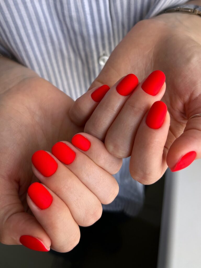 Make a bold statement with matte red oval nails for a confident yet simple office manicure