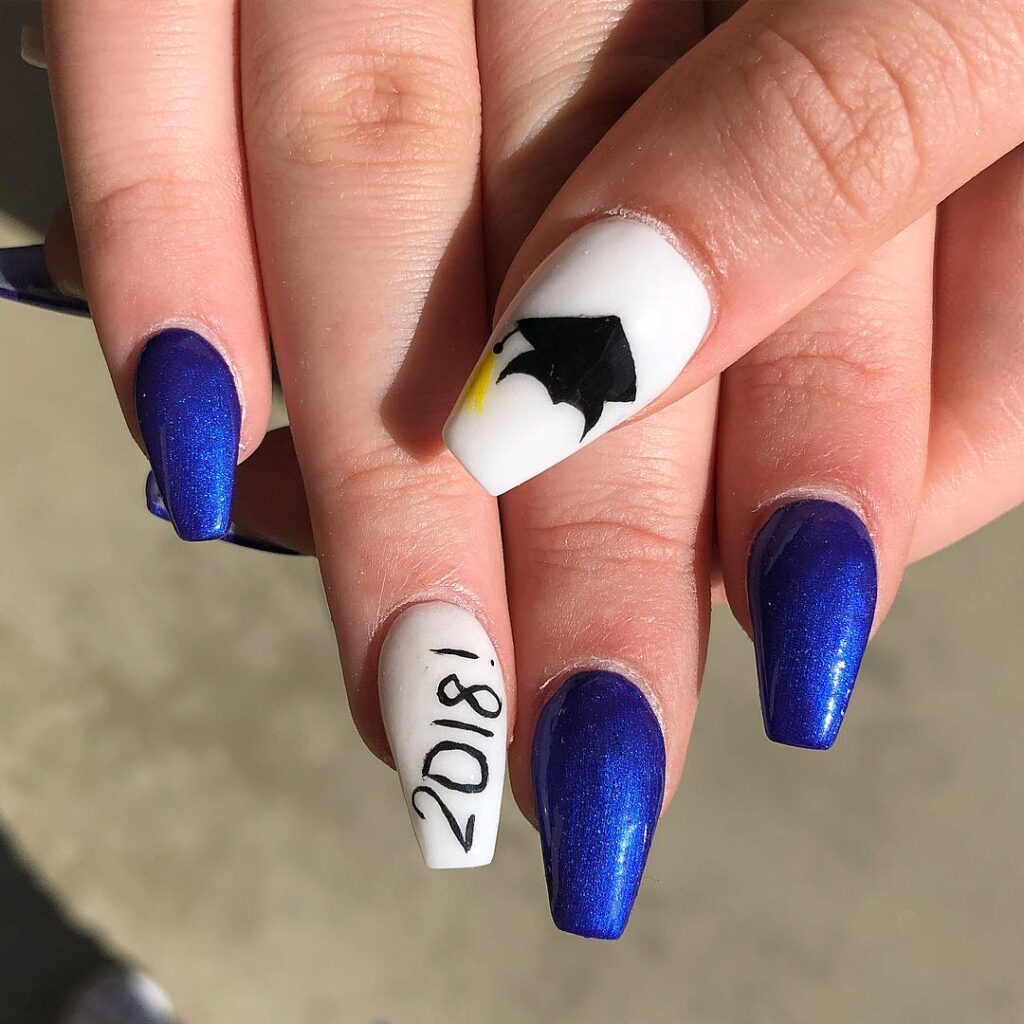 Metallic blue coffin nails with white accent art for bold graduation style