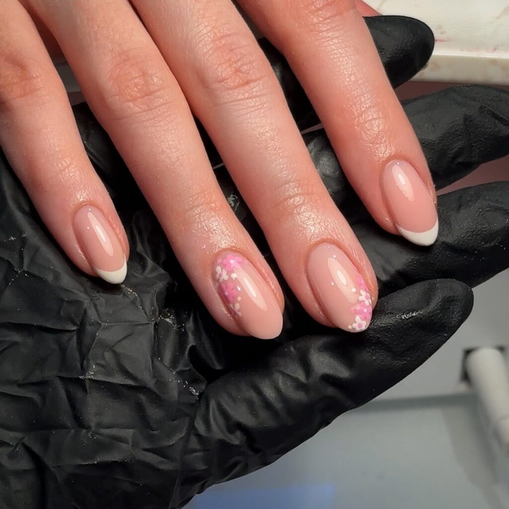 Nude Almond Nails with Subtle French Tips and Pastel Floral Confetti
